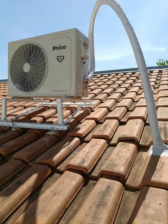 Condensadora instalada sobre o telhado com base metálica nivelada